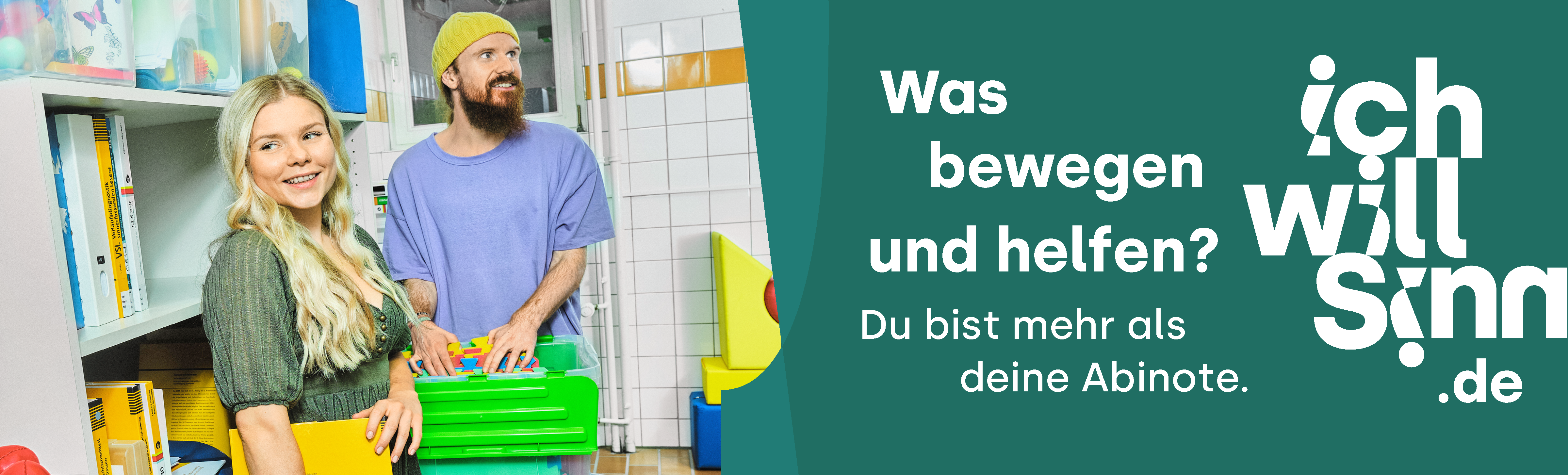 Das Bild zeigt zwei Personen im bunten Werkraum der Heilpädagogischen Ambulanz der Hochschule. Die junge Frau hat blonde lange Haare und trägt ein grünes Kleid. Sie lacht. Der juge Mann trägt einen dunklen Vollbart und eine gelbe Wollmütze.