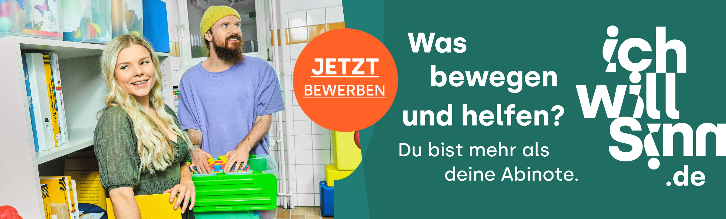 Das Bild zeigt zwei Personen im bunten Werkraum der Heilpädagogischen Ambulanz der Hochschule. Die junge Frau hat blonde lange Haare und trägt ein grünes Kleid. Sie lacht. Der juge Mann trägt einen dunklen Vollbart und eine gelbe Wollmütze.